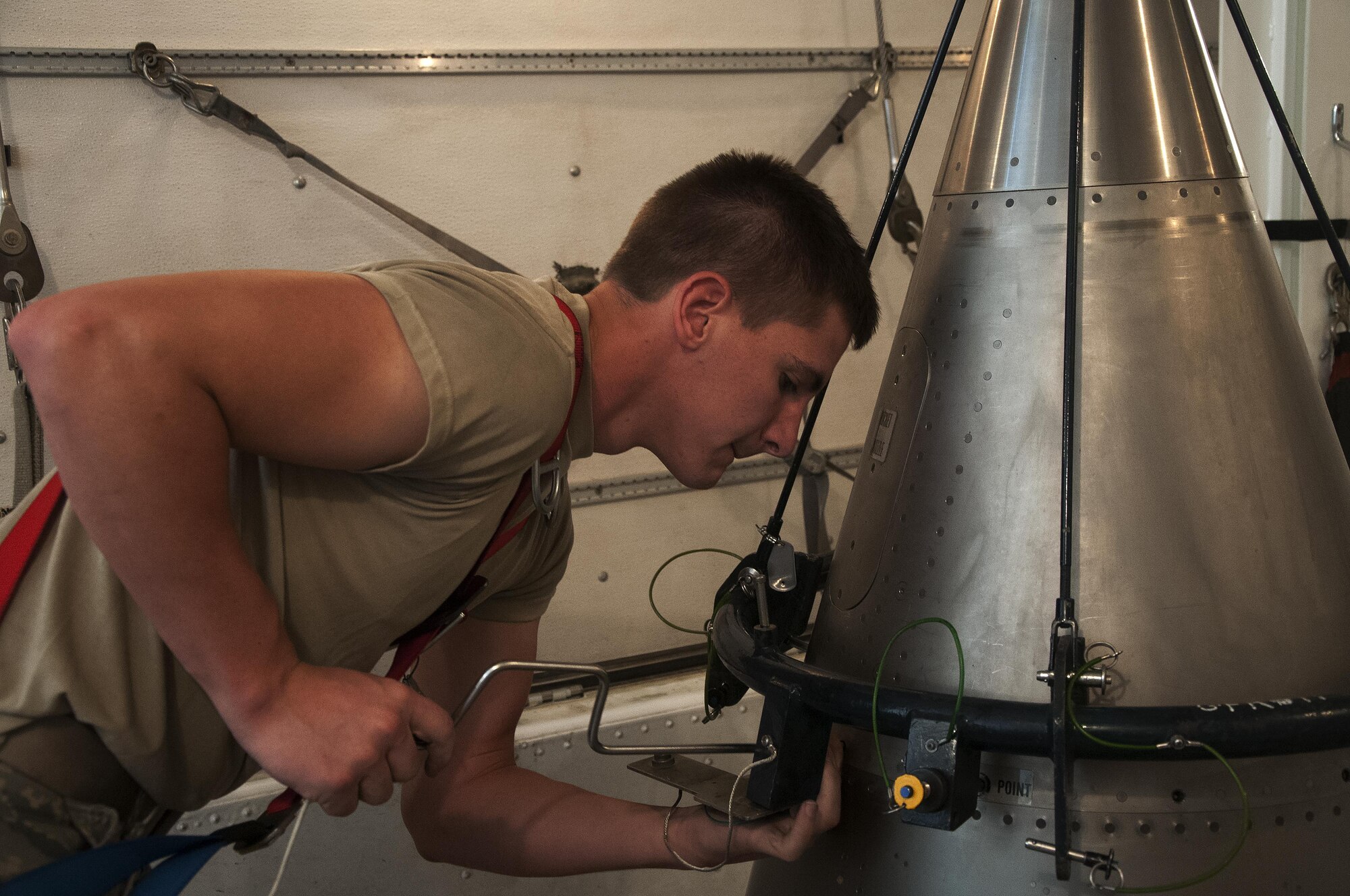 Airman 1st Class William Ray, 90th Missile Maintenance Squadron maintainer, removes the screws holding the nose point of a Minuteman III ICBM to the rest of the reentry system inside a payload transporter in the F.E. Warren Air Force Base, Wyo., missile complex, Aug. 24, 2016. The system was separated into two parts and secured inside a payload transporter. The 90th MMXS maintains 150 Minuteman III ICBMs and the associated LFs spread throughout three states and 9,600 square miles. (U.S. Air Force photo by Senior Airman Brandon Valle)