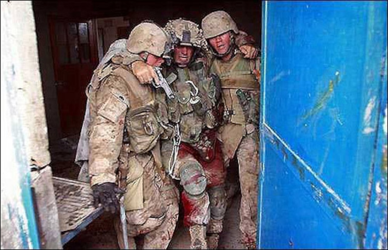 Then-Marine Corps 1st Sgt. Brad Kasal receives assistance from Marine Pfc. Christopher Marquez and Lance Cpl. Dane Shafer to escape the infamous “Hell House” in Fallujah, Iraq, where Marines were pinned down during a firefight during Operation Phantom Fury in November 2004. Kasal received the Navy Cross for his actions. Courtesy photo