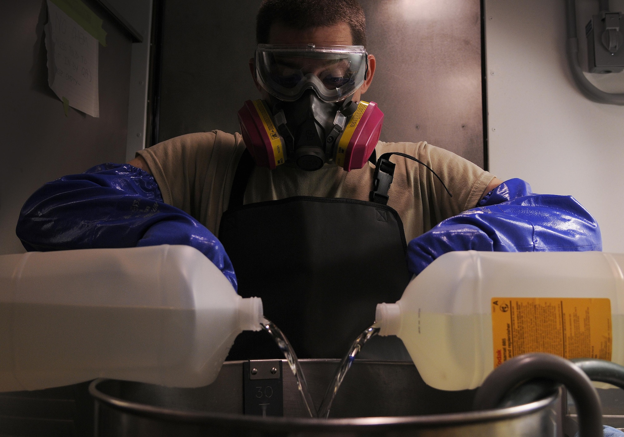 Staff Sgt. Christopher Hatch, 9IS aerial film processing section lead, pours fixer solution into a mixer Sept. 14, 2016, at Beale Air Force Base, California. Using the fixer and various other chemicals, film processors develop the wet-film imagery captured by the Optical Bar Camera. (Air Force photo by Airman 1st Class Taylor A. Workman)