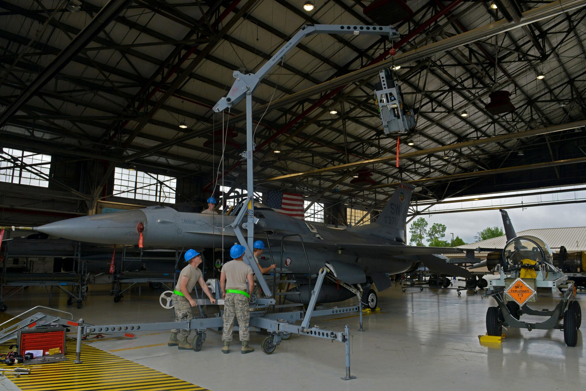 U.S. Airmen assigned to the 20th Component Maintenance Squadron egress flight lift an F-16CM Fighting Falcon seat with a skyhook crane for reinstallation following repairs at Shaw Air Force Base, S.C., Sept. 22, 2016. Skyhook cranes are used to lift objects up to 5,000 pounds such as aircraft canopies. (U.S. Air Force photo by Airman 1st Class Destinee Sweeney)