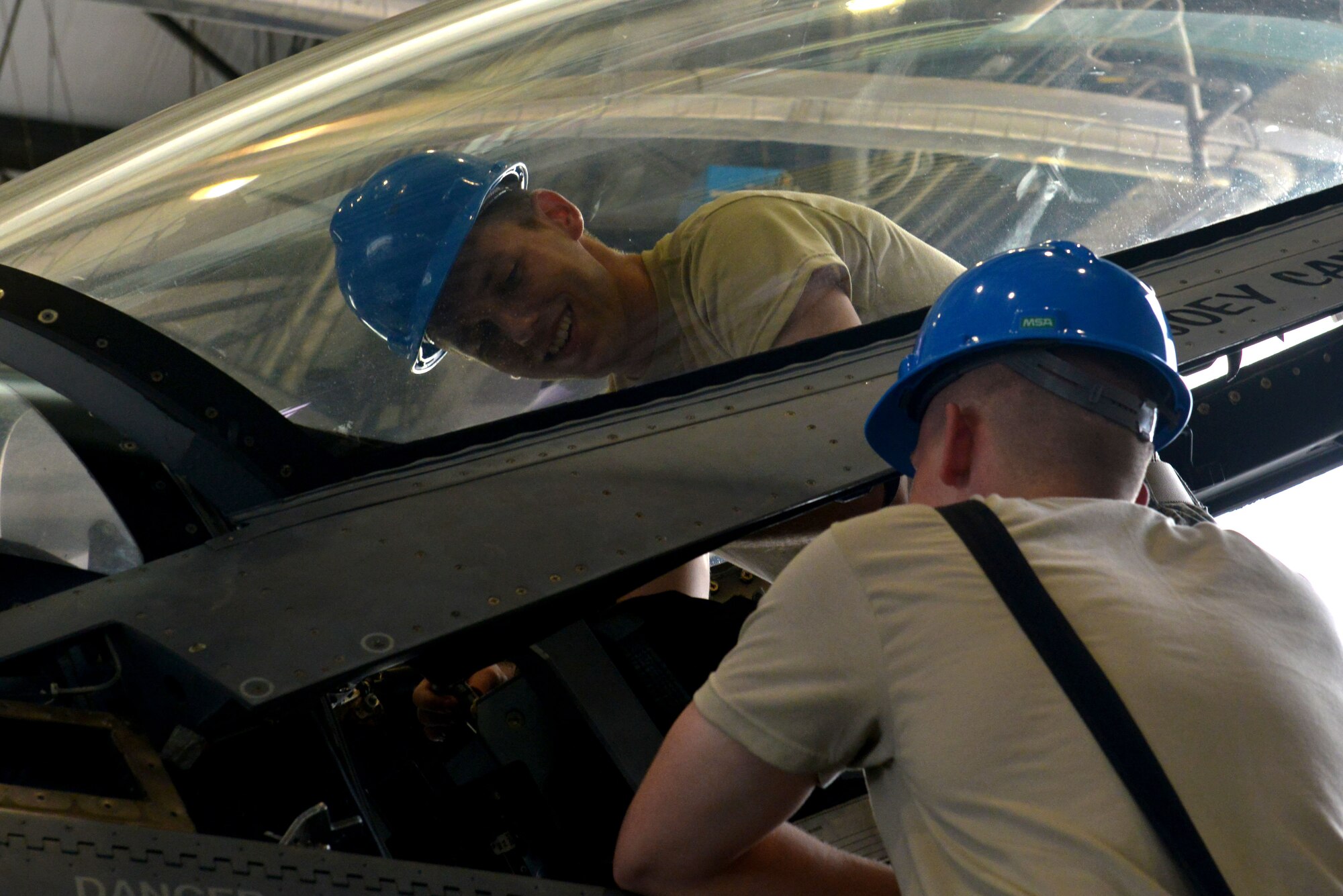 From left, U.S. Air Force Senior Airman Kyle Books, 20th Component Maintenance Squadron egress journeyman, smiles at Airman 1st Class Justin Spammacher, 20th CMS egress apprentice, while securing a seat onto an F-16CM Fighting Falcon at Shaw Air Force Base, S.C., Sept. 22, 2016. The 20th CMS egress Airmen inspect, maintain and reinstall the seat, canopy and rails of F-16CM Fighting Falcons. (U.S. Air Force photo by Airman 1st Class Destinee Sweeney)
