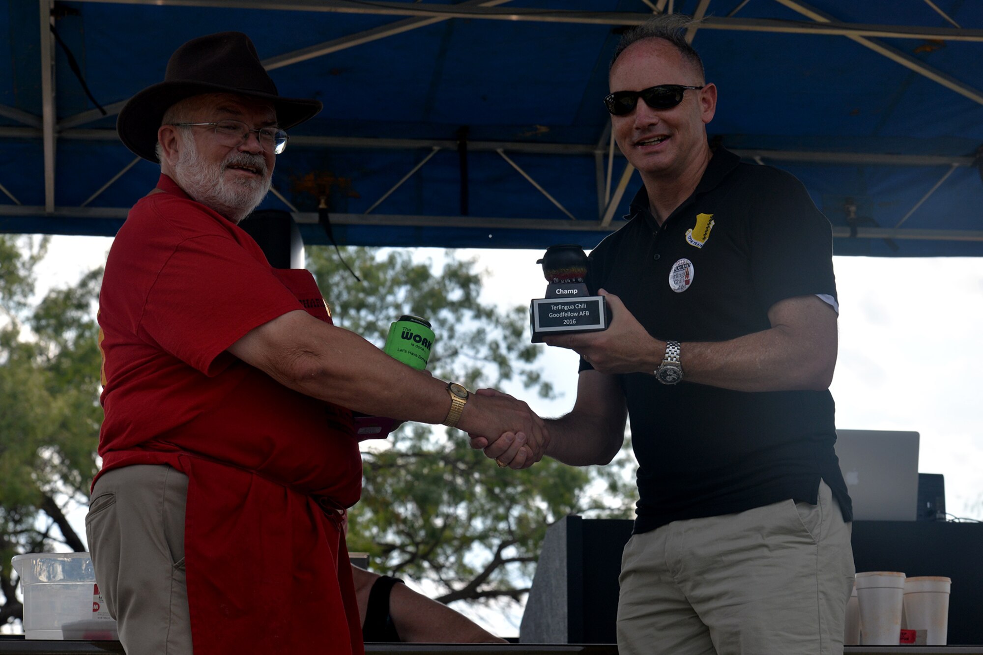 U.S. Air Force Col. Michael Downs, 17th Training Wing Commander, presents the 2016 Terlingua 1st place award to John Pecorino, 43rd Annual Armed Forces Chili Cook-Off competitor, during the Ruckus at the Rec Camp at the Goodfellow Air Force Base Recreation Camp, San Angelo, Texas, Sept. 24, 2016. The top three Terlingua winners will earn a place to compete in the Original International Championship Chili Cook-Off in Terlingua, Texas. (U.S. Air Force photo by Airman 1st Class Randall Moose/Released)