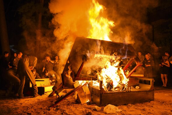 Officers from various fighter squadrons lift a piano into a burning pit, Sept. 23, 2016, at Seymour Johnson Air Force Base, North Carolina. Pianos are burned every year in memory of the Battle of Britain during World War II and those pilots who never came home. (U.S. Air Force photo by Airman Shawna L. Keyes)