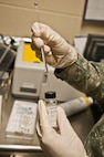 A bioenvironmental engineering technician with the 5th Medical Group extracts methanol with a syringe at Minot Air Force Base, N.D., Sept. 22, 2016. The methanol is used to flush out the syringes before any sampling can take place. (U.S. Air Force photo/Airman 1st Class Jonathan McElderry)