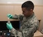 Airman 1st Class Kyle Hipol, a bioenvironmental engineering technician with the 5th Medical Group, pours Colilert into a water sample at Minot Air Force Base, N.D., Sept. 22, 2016. Colilert is a dried manure that is used to test water for bacteria by allowing the bacteria to grow inside water after being mixed.  (U.S. Air Force photo/Airman 1st Class Jonathan McElderry)