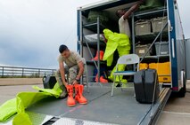 Senior Airman Isaac Darko, right, and Airman 1st Class Kyle Hipol, bioenvironmental engineering technicians with the 5th Medical Group, prepare to put on the chemical suits at Minot Air Force Base, N.D., Sept. 22, 2016. Every three months, the bioenvironmental engineering technicians go to all of the missile alert facilities for water sampling. (U.S. Air Force photo/Airman 1st Class Jonathan McElderry)