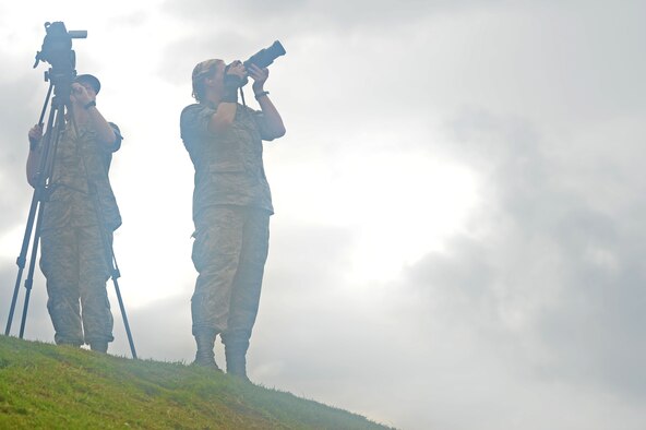 From left, U.S. Air Force Airman 1st Class Cassidy Woody, 20th Fighter Wing Public Affairs broadcast journalist apprentice, and Airman 1st Class Kelsey Tucker, 20th FW PA photojournalist apprentice, document F-16CM Fighting Falcons performing inert live-rocket demonstrations at Poinsett Electronic Combat Range, Wedgefield, S.C., Sept. 23, 2016. Photojournalists and broadcast journalists are tasked with documenting base operations for historical and investigative purposes. (U.S. Air Force photo by Airman 1st Class Christopher Maldonado)