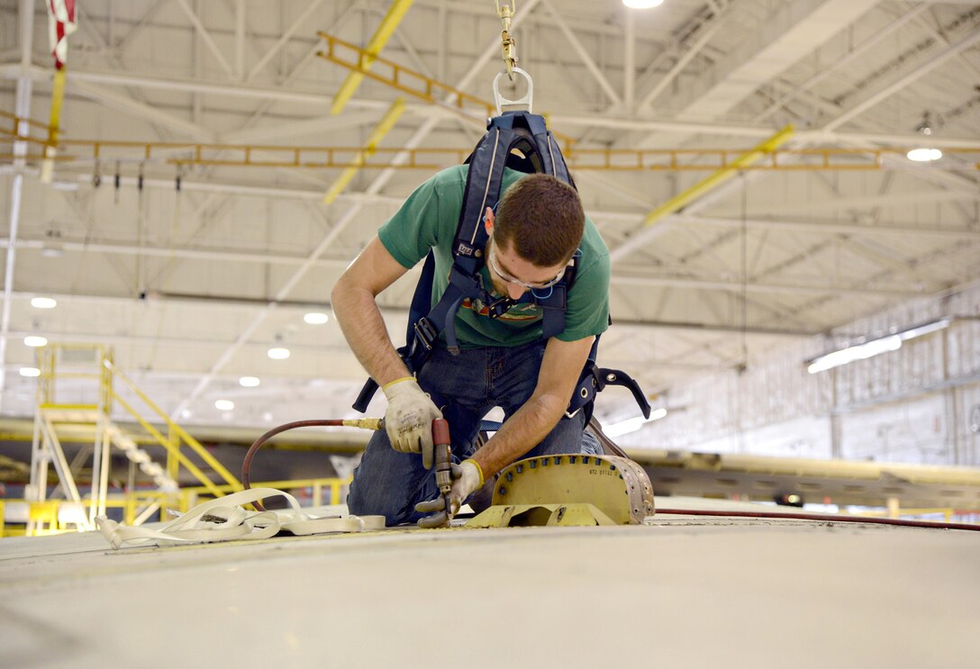 Jamin Alato, an aircraft mechanic with the 565th Aircraft Maintenance Squadron, replaces nut plates on "Ghost Rider's" vertical stabilizer. The B-52H Stratofortress, tail number 61-007, recently underwent extensive programmed depot maintenance at Tinker Air Force Base. 'Ghost Rider' is the first B-52H to ever be regenerated from long-term storage with the 309th Aerospace Maintenance and Regeneration Group at Davis-Monthan AFB, Ariz., and returned to fully-operational flying status. (Air Force photo by Kelly White)