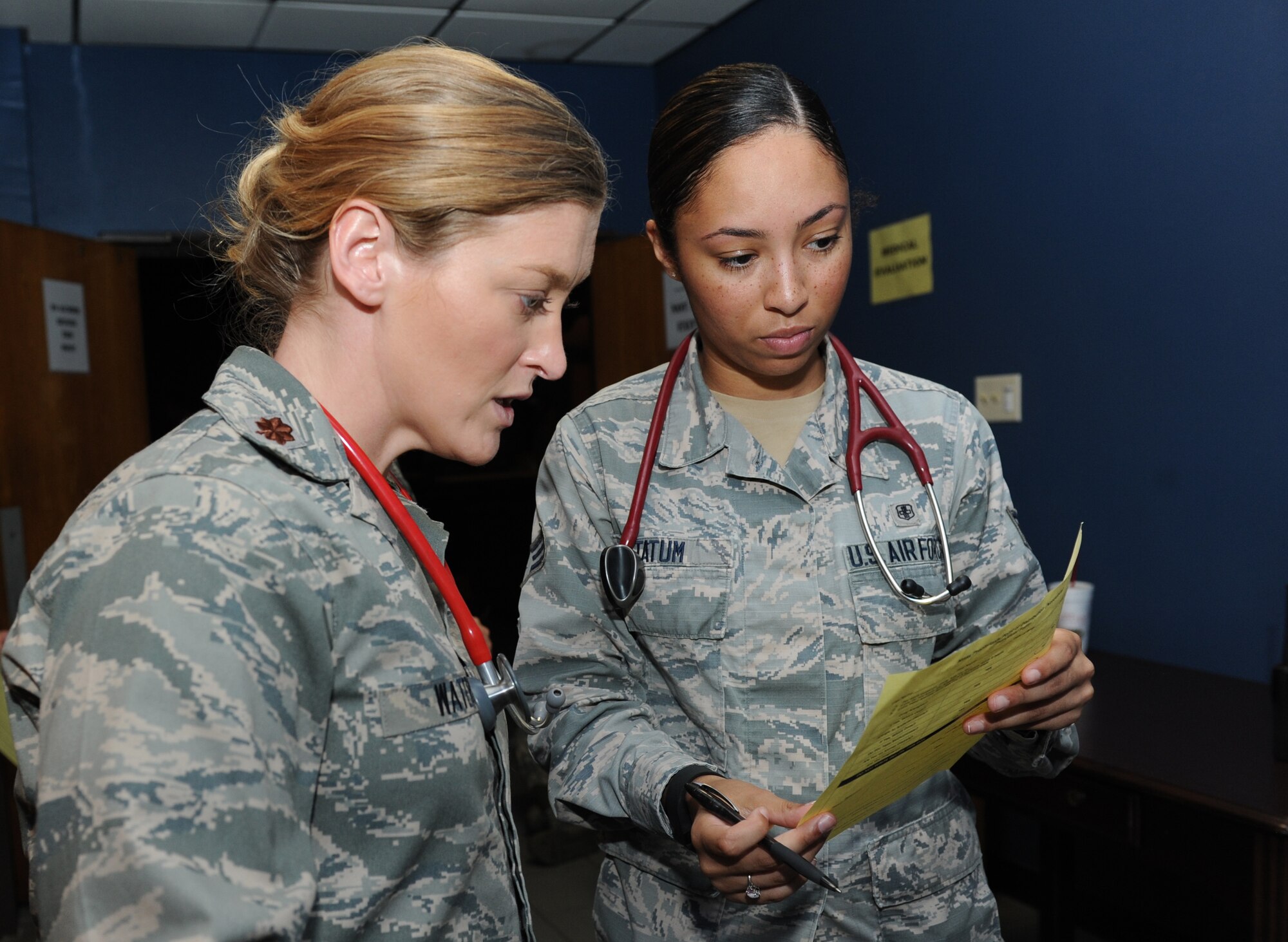 Maj. (Dr.) Heather Waters, 81st Medical Operations Squadron family health medical director, and Senior Airman Jennifer Tatum, 81st MDOS family health technician, discuss patient situations during a public health emergency exercise at Vandenberg Hall Sept. 22, 2016, on Keesler Air Force Base, Miss. The weeklong exercise tested how the 81st Medical Group responds during a mass sickness outbreak. The 81st MDG staged a point of dispensing to diagnose, discuss treatment plans and provide medicine to sick Airmen.