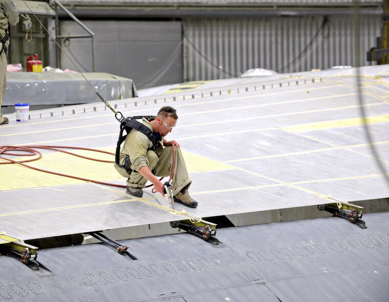 James Reese, 566th Aircraft Maintenance Squadron, applies aerodynamic sealant to the top of “Ghost Rider’s” left wing. Once the sealant is applied, the aircraft can be painted and sent back into the fight.  (Air Force photo by Kelly White)