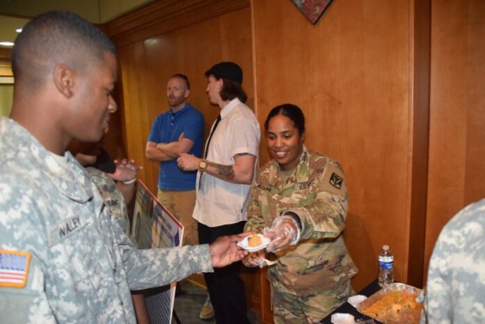 Sgt. Brenda Collins, 2-1 ADA Battalion, serves arepa de maiz, a popular dessert from Dominican Republic during the Hispanic heritage observance in Daegu, Republic of Korea, Sept. 21. Hispanic Heritage Month is recognized Sept. 15 - Oct. 15, and 2nd Battalion, 1st Air Defense Artillery Regiment hosted the area IV observance in the Republic of Korea. 