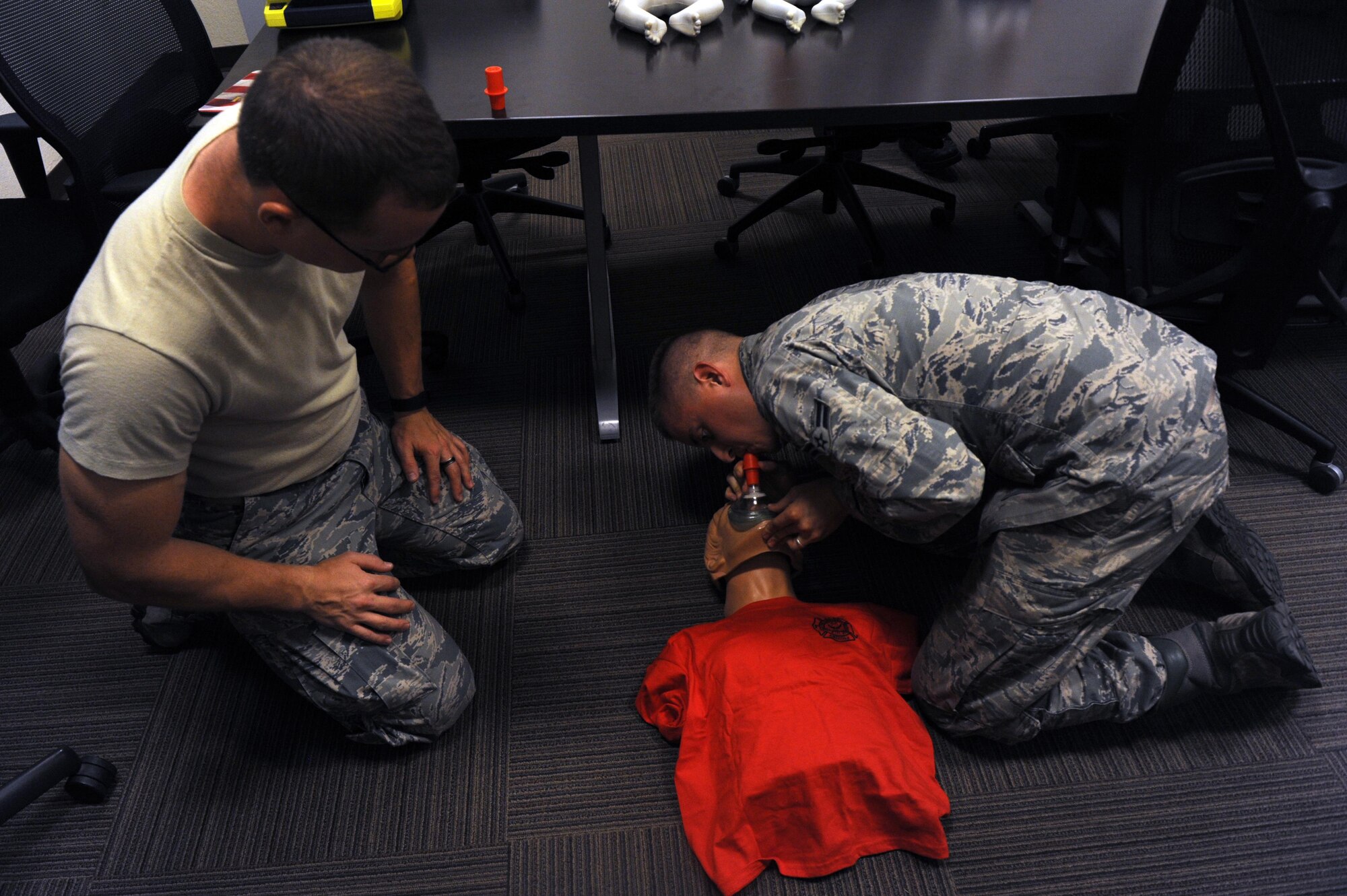 Senior Airman Timothy Wallace, 56th Medical Operation Squadron aerospace medical technician, observes Airman 1st Class Geoffrey Moreland, 56th Civil Engineer Squadron firefighter, performing cardiopulmonary resuscitation with a pocket CPR mask Sept. 20, 2016 at Luke Air force Base, Ariz. The pocket CPR mask contains a one way valve to prevent the spread of disease. (U.S. Air Force Photos by Airman 1st Class Pedro Mota)
