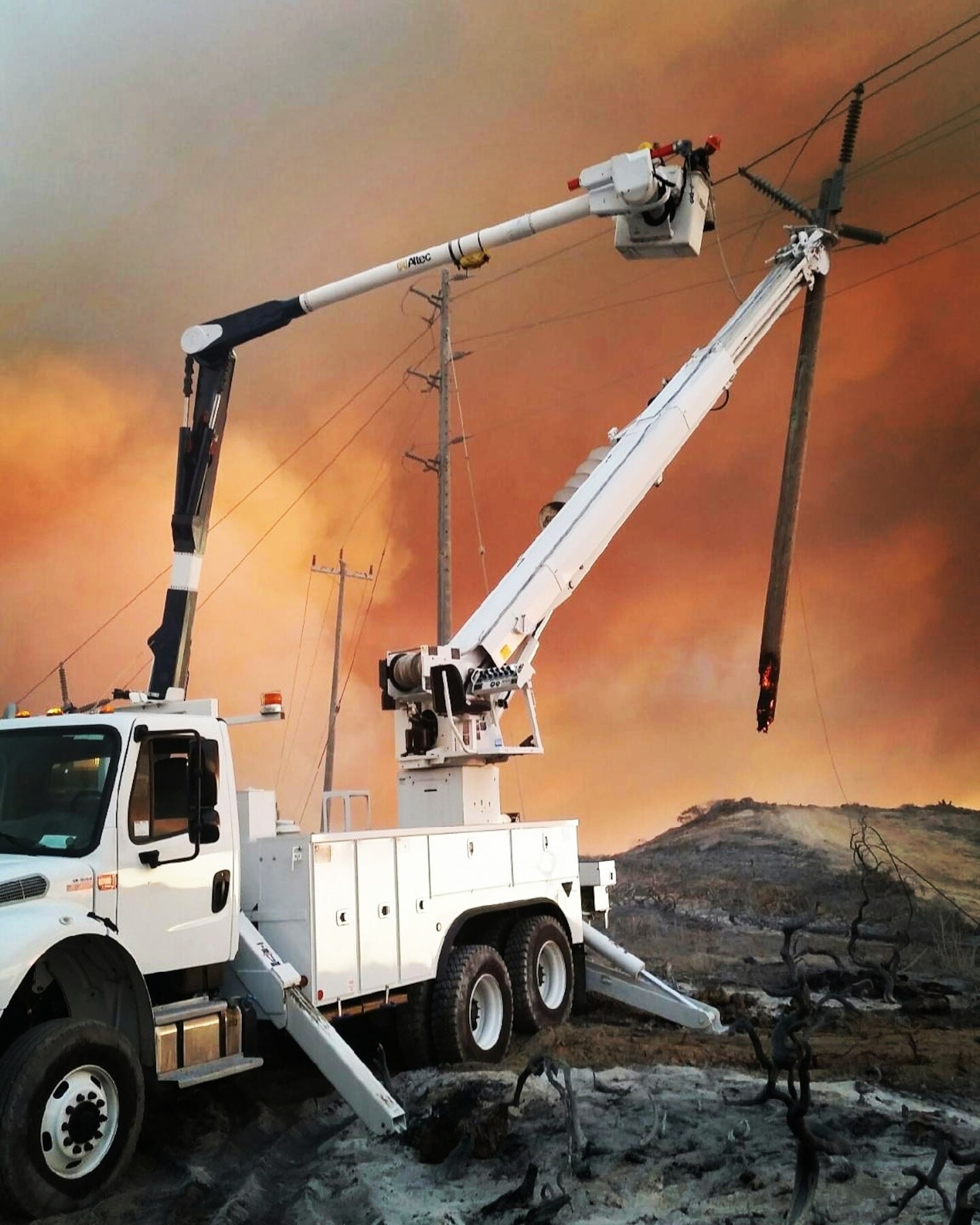 Electricians work to deengage power after a fire swept through portions of South Base, Sept. 19, 2016, Vandenberg Air Force Base, Calif. Vandenberg personnel, alongside community partners and a specialized incident management team, have worked to extinguish five separate wildland fires, here, since Sept. 17. (U.S. Air Force photo by Senior Airman Keith Martineau/Released)