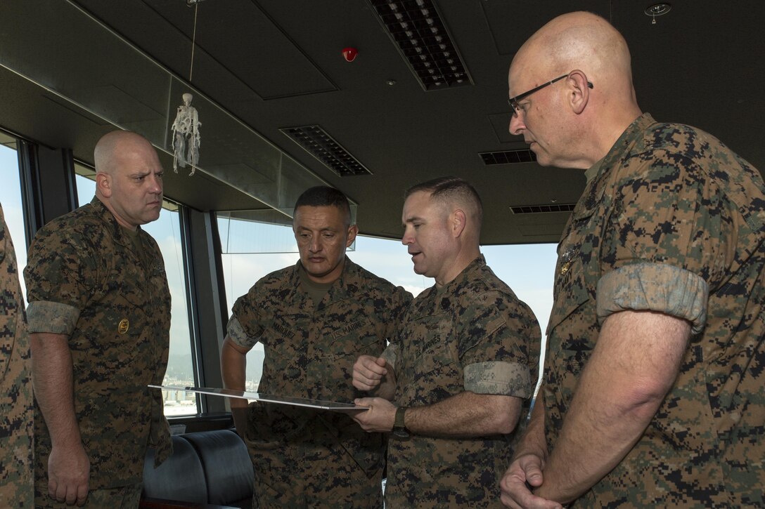 U.S. Marine Corps Sgt. Maj. Christopher J. Garza, third from left, sergeant major of Marine Corps Air Station (MCAS) Iwakuni, shows a map of the air station to U.S. Navy Command Master Chief Petty Officer Daniel K. Field, first, 1st Marine Aircraft Wing (MAW) command master chief, U.S. Marine Corps Sgt. Maj. Mario A. Marquez, second, 1st MAW sergeant major, and U.S. Navy Command Master Chief Petty Officer Michael J. Fasano, fourth, III Marine Expeditionary Force (MEF) command master chief, during a tour of MCAS Iwakuni, Japan, Sept. 27, 2016. The command visit entailed a meeting with the senior enlisted leaders of the air station, staff noncommissioned officer professional military education, breakfast with noncommissioned officers and afforded the senior enlisted leaders of III MEF, Marine Corps Installations Pacific and 1st MAW the opportunity to view the transformation of the air station. (U.S. Marine Corps photo by Lance Cpl. Aaron Henson)