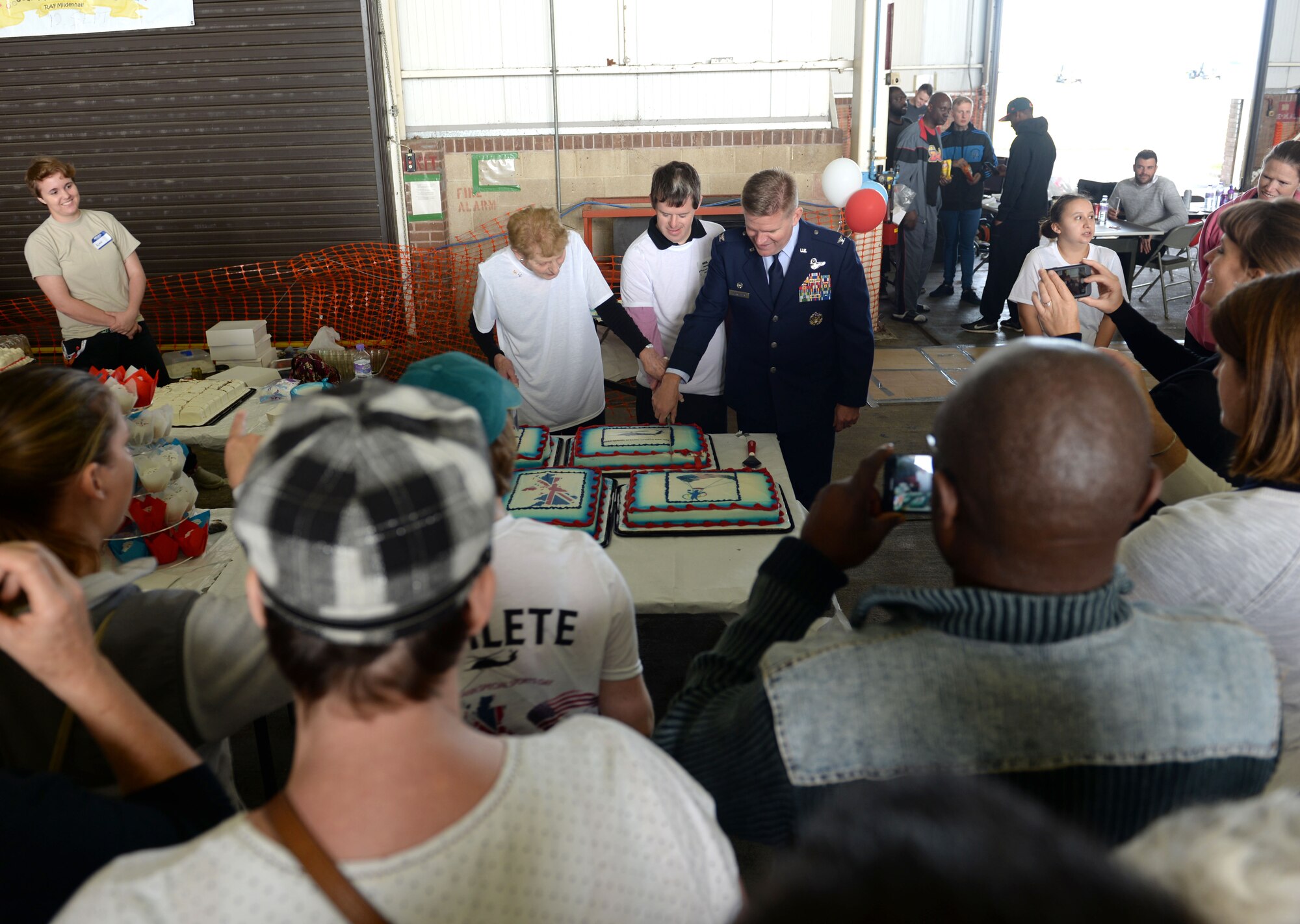 U.S. Air Force Col. Thomas Torkelson, right, 100th Air Refueling Wing commander, Neil Draper, middle, and Iris Weimer cut the cake at the 35th Annual Joan Mann Special Sports Day Sept. 24, 2016, on RAF Mildenhall, England. The event included a 100-yard race, obstacle course, basketball shoot-out, ball toss, lunch, cake and more, giving the more than 200 athletes plenty of activities to participate in. (U.S. Air Force photo by Staff Sgt. Kate Thornton)