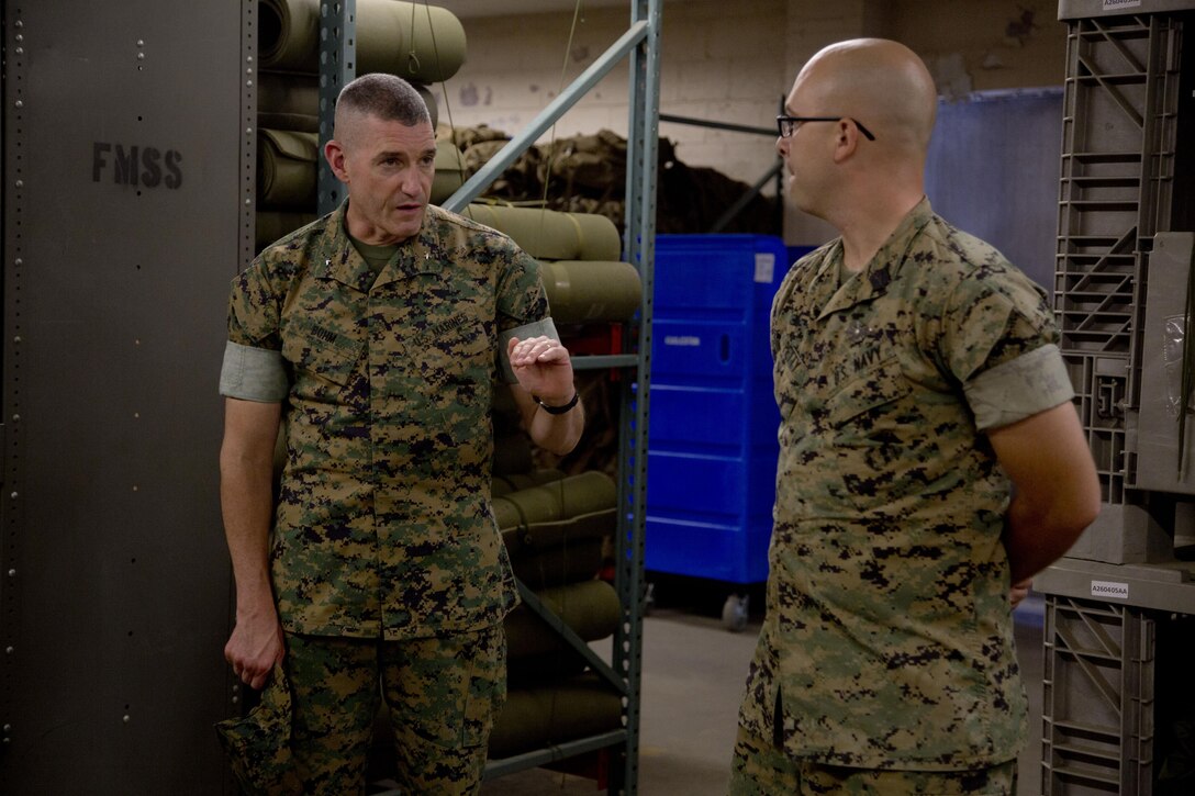 BGEN Bohm talks with HM1 Petty while touring the warehouse at FMTB-E.