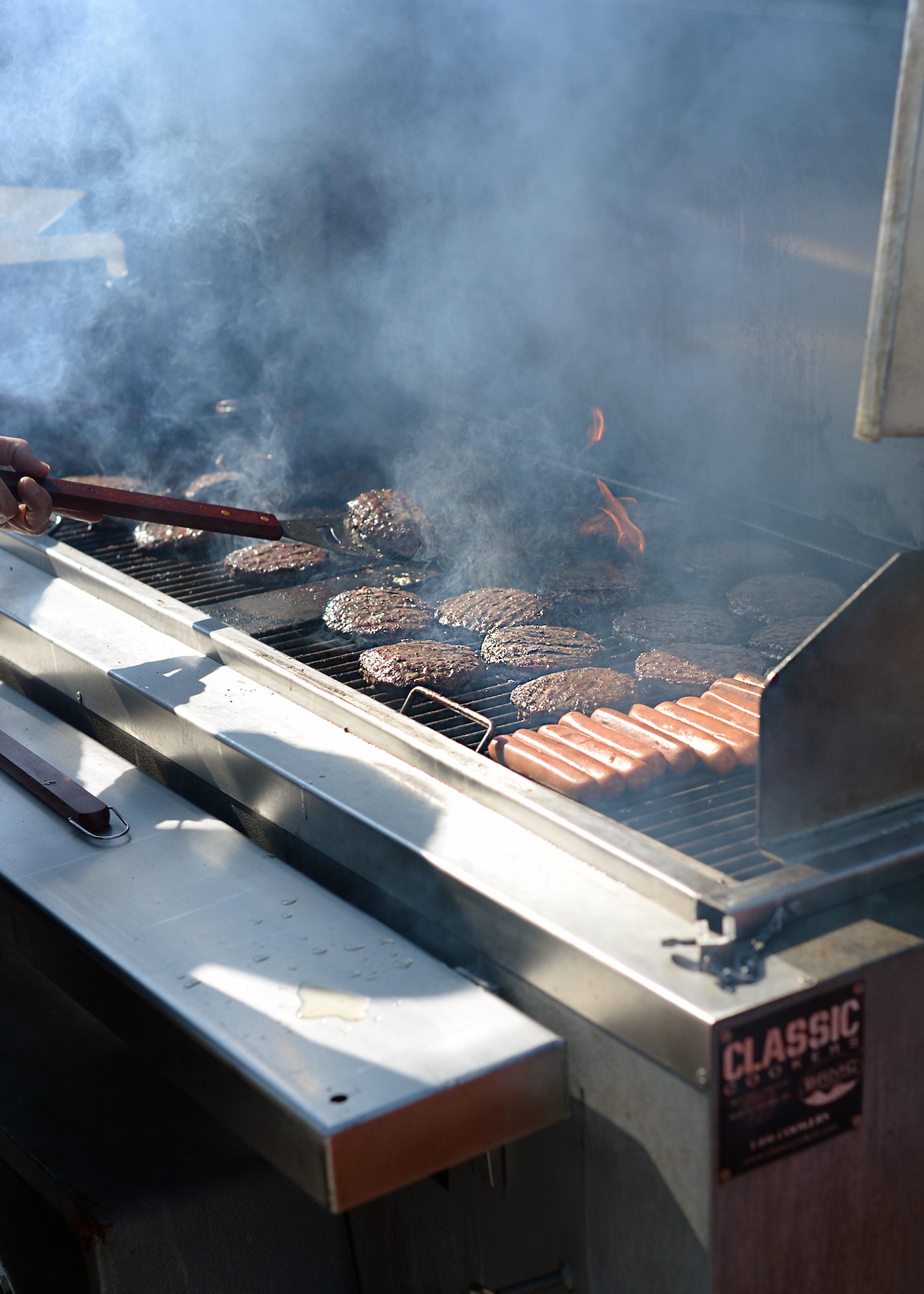 Hamburgers and hot dogs cook at Vogelweh Military Complex, Germany, Sept. 22, 2016. The KMC 1st Four provided food and refreshments for the students after the adaptive sports soccer game. (U.S. Air Force photo by Jimmie D. Pike)