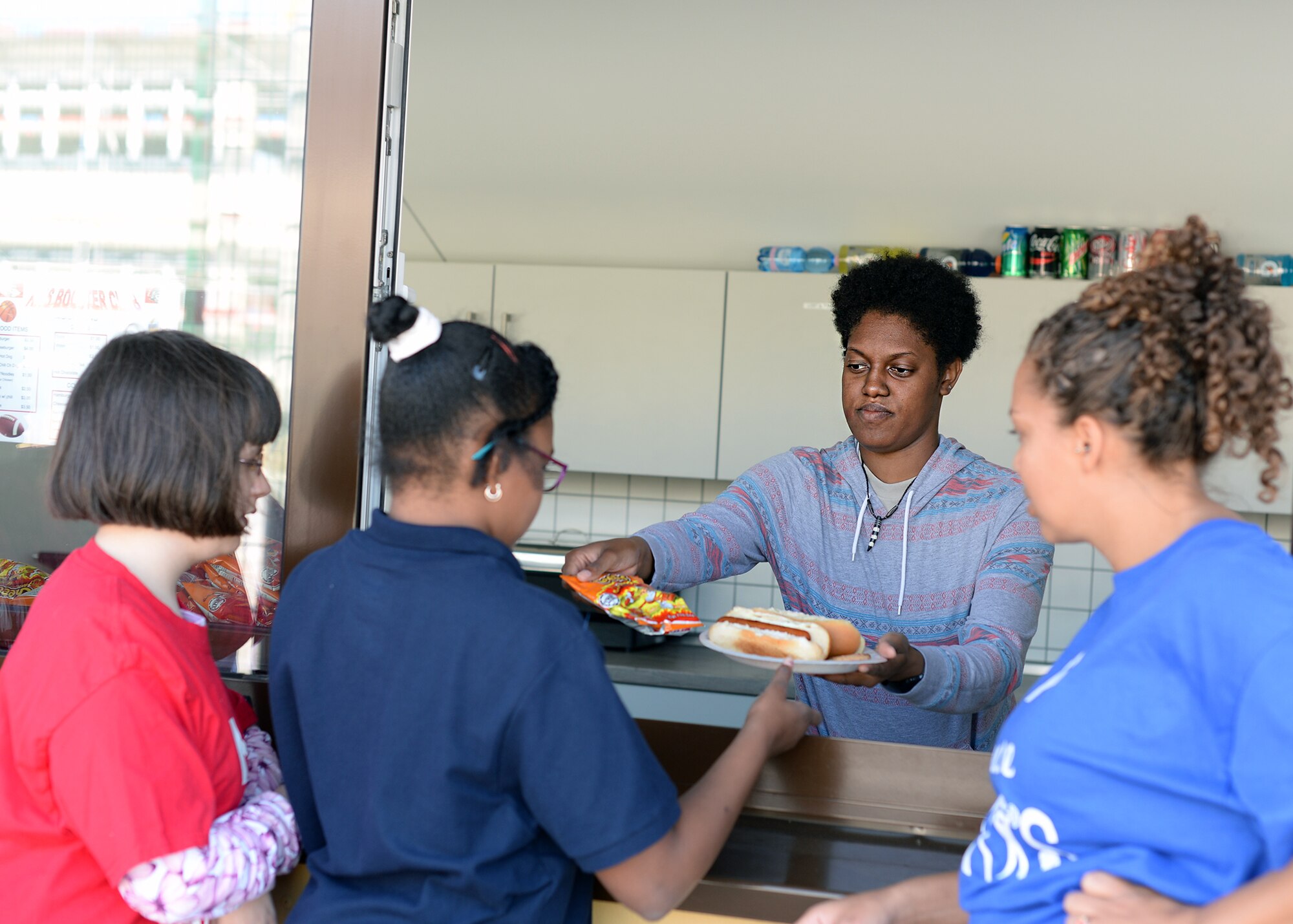 Airman 1st Class Jazmine Washington, 86th Medical Operations Squadron dental technician, serves food to students after an adaptive sports soccer game at Vogelweh Military Complex, Germany, Sept. 22, 2016. Airmen came out to volunteer and help make the event run smoothly for the students participating. (U.S. Air Force photo by Senior Airman Jimmie D. Pike)