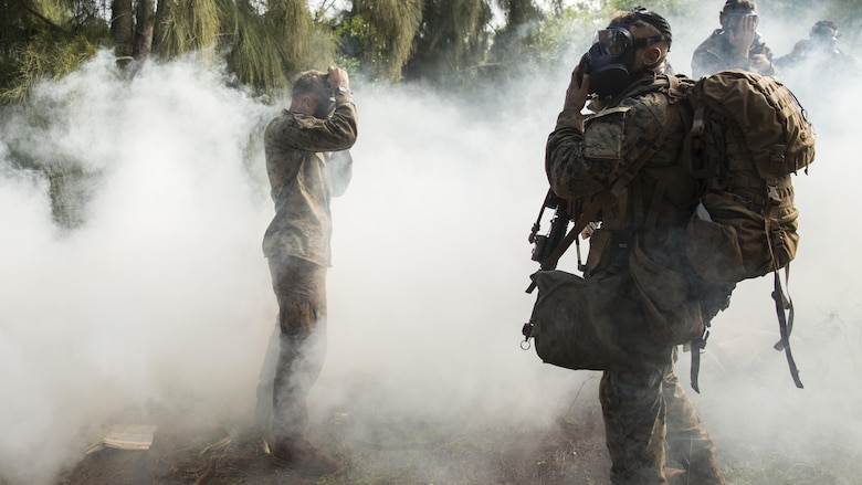 Marines don their gas masks as simulated hostiles use O-chlorobenzalmalononitrile gas during a raid as part of a training exercise aboard the Kahuku Training Facility, Sept. 20, 2016. The exercise is part of a 7-week-long training known as the Advance Infantry Course. The Advance Infantry Course, which is conducted by the Advance Infantry Battalion, Detachment Hawaii, is an advanced 0311 rifleman Military Occupational Specialty course for squad leaders who are currently serving in the operating field. 