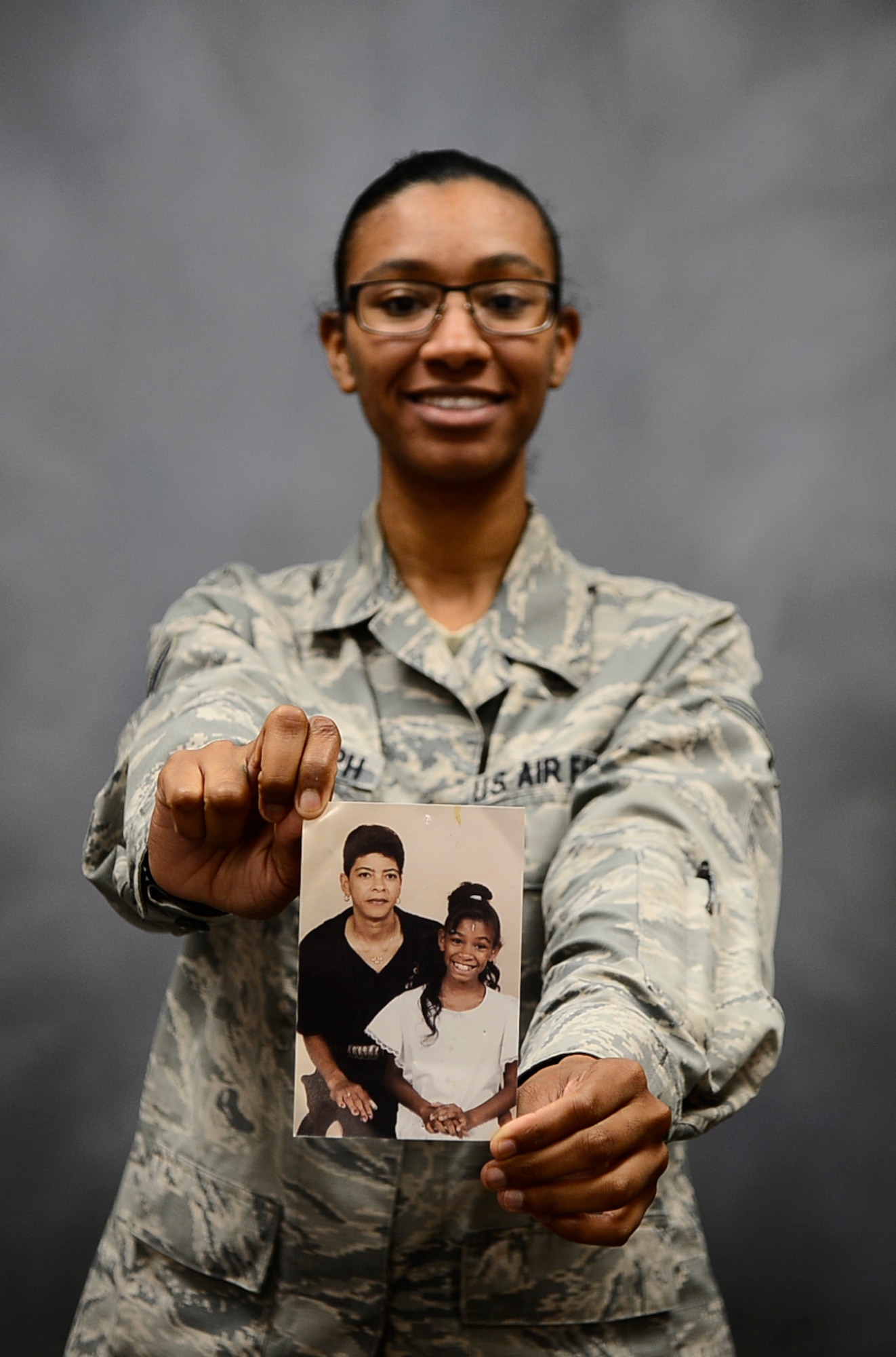 Senior Airmen Jenay Randolph, a photojournalist assigned to the 6th Air Mobility Wing Public Affairs office, holds out a photo of her and her mother at MacDill Air Force Base, Fla., Aug. 22, 2016. Randolph’s mother passed away when she was eight years old. (U.S. Air Force photo by Senior Airman Tori Schultz)