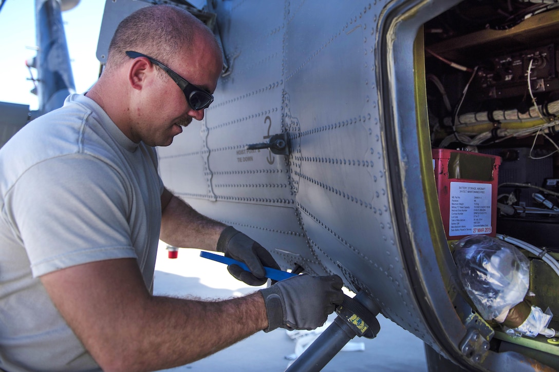 Air Force Staff Sgt. Michael Carrubba installs a fuel dump tube on an HH-60G Pave Hawk helicopter at Bagram Airfield, Afghanistan, Sept. 26, 2016. Carrubba is a crew chief assigned to the 83rd Expeditionary Rescue Squadron. Air Force photo by Senior Airman Justyn M. Freeman