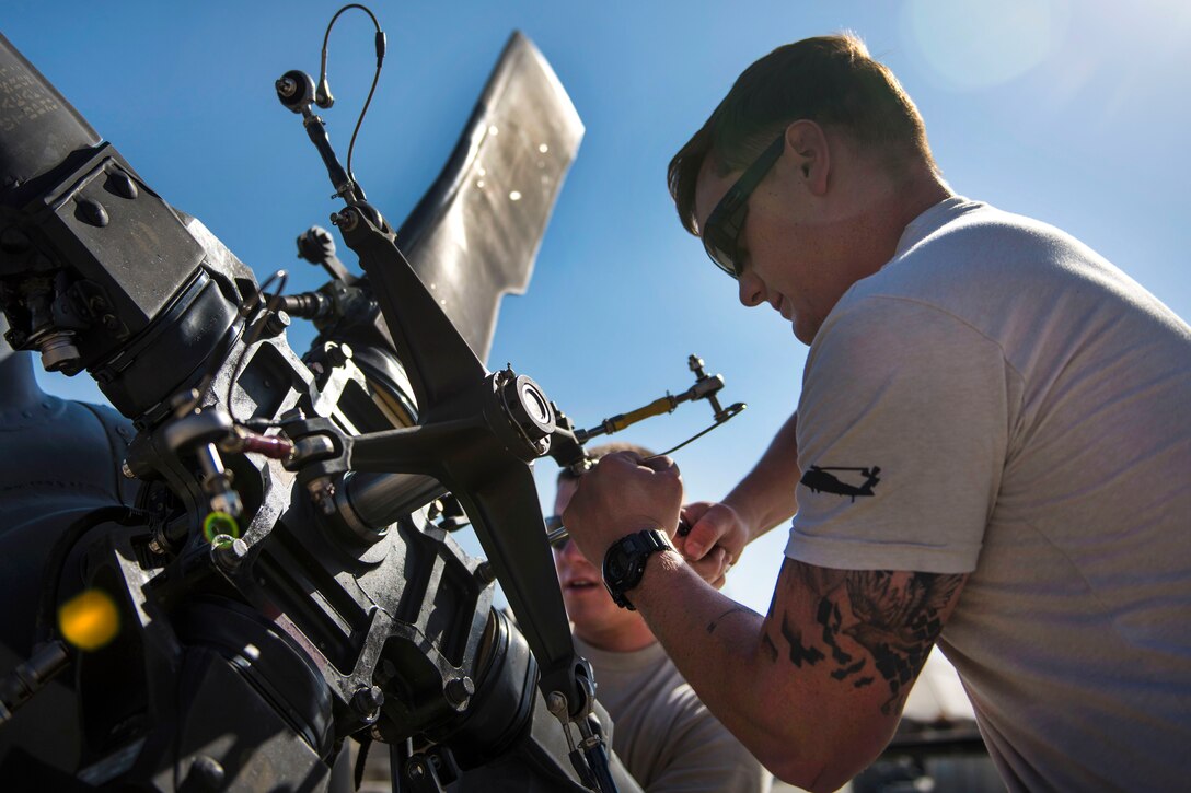 Air Force Staff Sgt. Sam Carroll, foreground, unfolds a tail rotor blade on an HH-60G Pave Hawk helicopter at Bagram Airfield, Afghanistan, Sept. 26, 2016. Carroll is a crew chief assigned to the 83rd Expeditionary Rescue Squadron. Air Force photo by Senior Airman Justyn M. Freeman