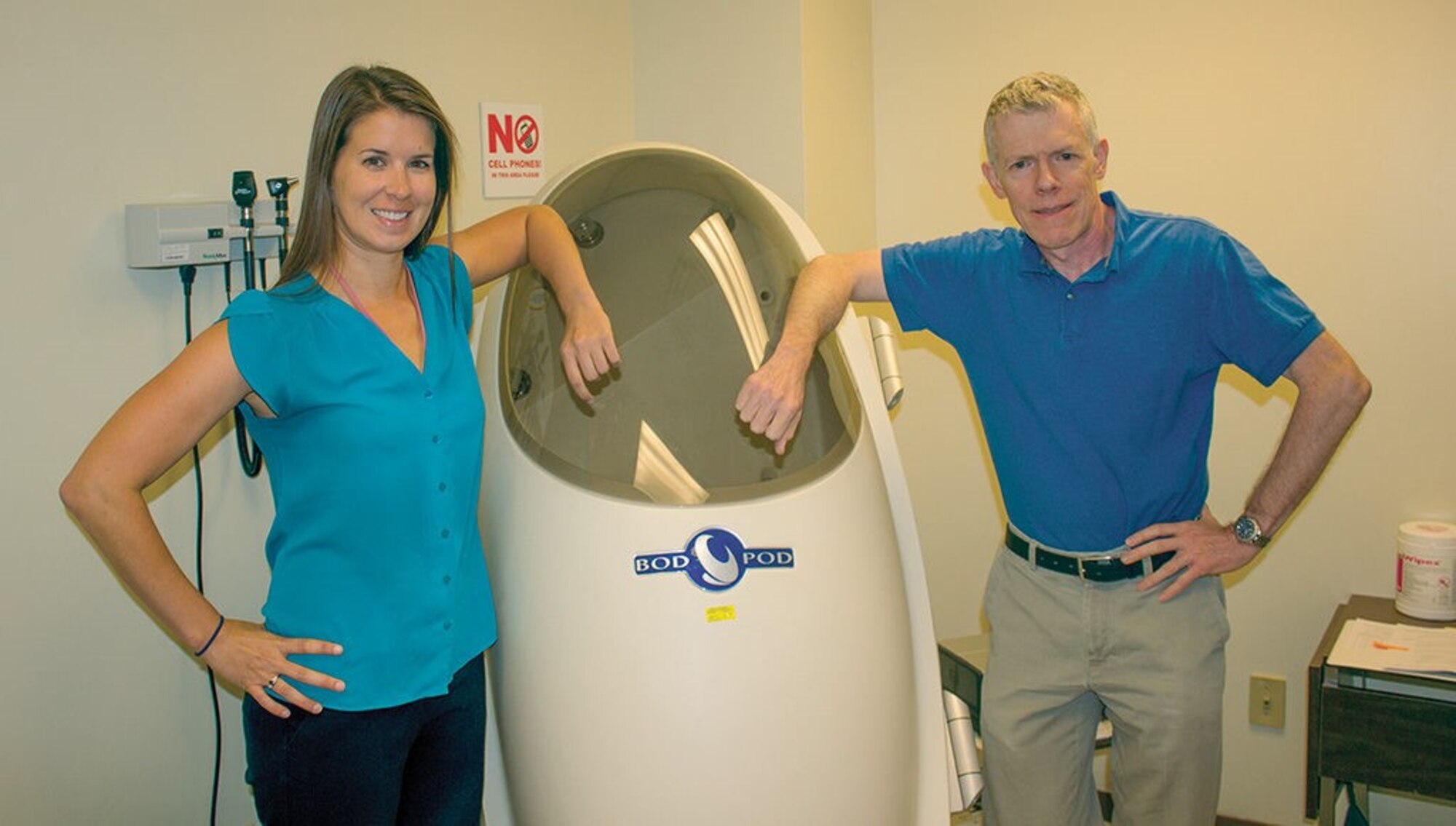 Kirsten David, Kirtland dietician, and Guy Leahy, Health Promotion Program coordinator, stand with the BodPod, a device that measures body fat percentage. They have a variety of services available to Airmen who want help meeting health and fitness goals. (Photo by Bud Cordova)