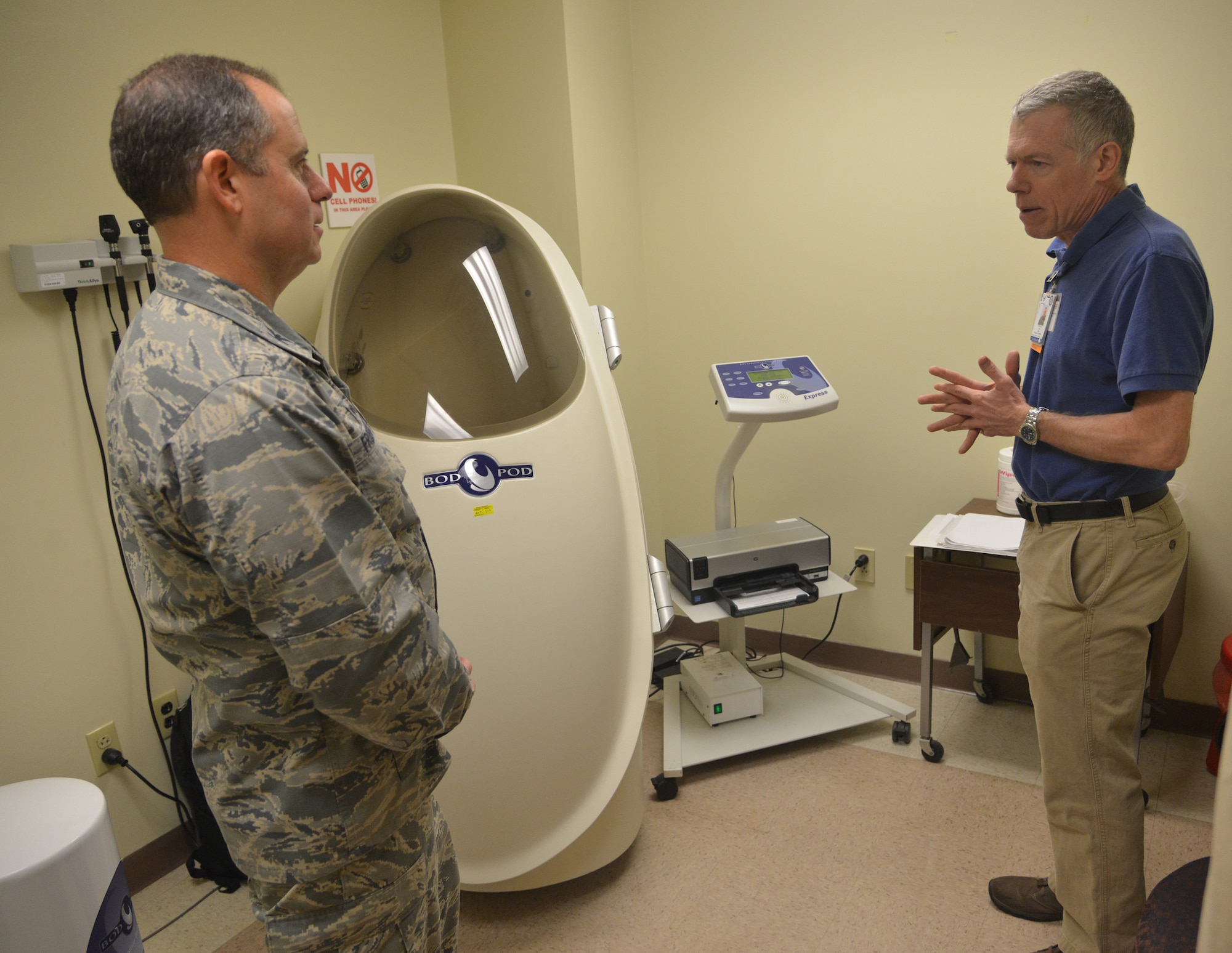 Col. Eric Froehlich, 377th Air Base Wing commander, discusses the BodPod with Health Promotion Program Coordinator Guy Leahy. The BodPod is a device that measures body fat percentage, and is one of a variety of services available to Airmen who want help meeting health and fitness goals. (Photo by Todd Berenger)