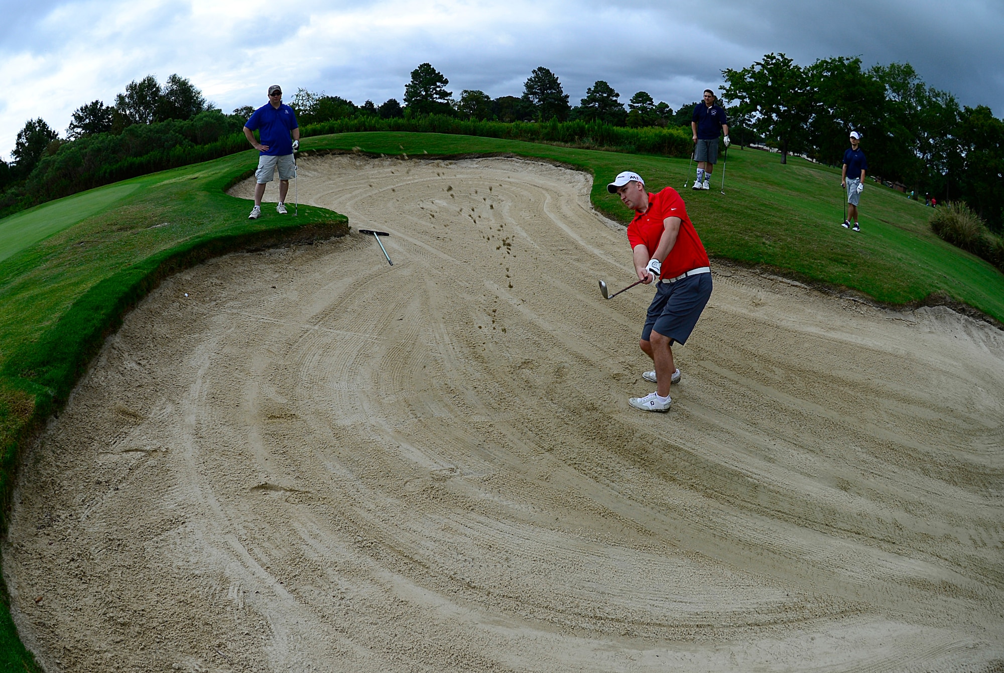 U.S. Air Force Staff Sgt. Rob Vineyard, 633rd Comptroller Squadron NCO in charge of military pay, hits a golf ball out of a sand trap during the Fall 2016 Commander’s Cup at Joint Base Langley-Eustis, Va., Sept. 23, 2016. JBLE and Hampton Roads community members had the opportunity to take golfing lessons with Joanna Coe, Ladies Professional Golf Association professional golfer. (U.S. Air Force photo by Airman 1st Class Kaylee Dubois)