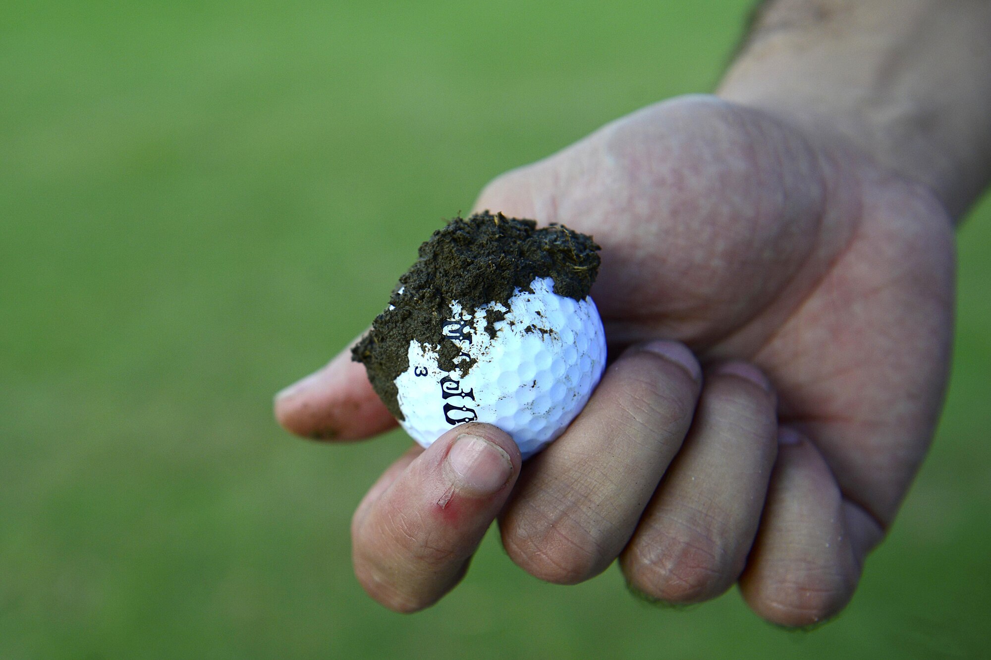 A Fall 2016 Commander’s Cup participant holds a dirt-covered golf ball during the tournament at Joint Base Langley-Eustis, Va., Sept. 23, 2016. The tournament included 18 holes of golf, lunch and a chance to win gift certificates to the JBLE golf courses. (U.S. Air Force photo by Airman 1st Class Kaylee Dubois)