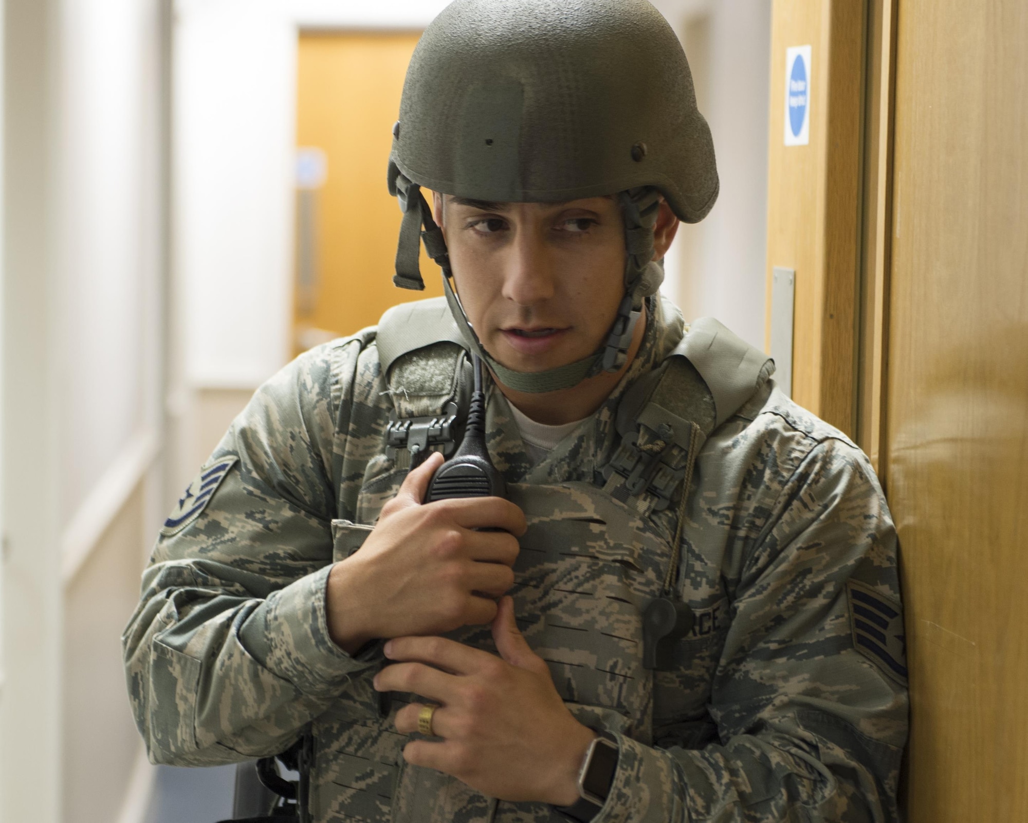U.S. Air Force Staff Sgt. Christian Varela, 48th Security Forces Squadron response force leader, keeps in communication with his team while monitoring a hallway during an active shooter exercise at Royal Air Force Lakenheath, England, Sept. 22. Active shooter exercises give defenders a chance to test their capabilities in a realistic situation and environment. (U.S. Air Force photo/Senior Airman Malcolm Mayfield)