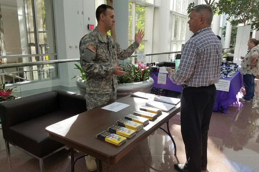 Army Sgt. Jimmy Garrett speaks to a visitor during the Army National Guard Preparedness Expo to support National Preparedness Month at Arlington Hall Station in Arlington, Va.