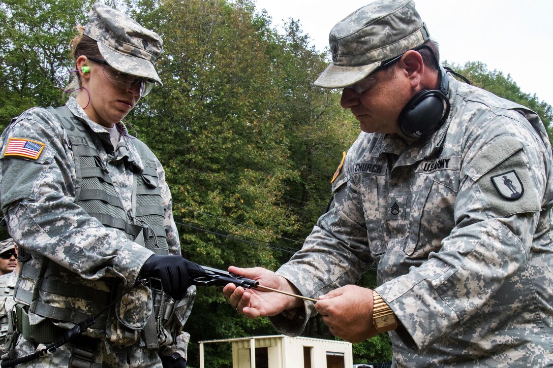 Army Staff Sgt. Thomas Church, right, safety checks a 9 mm Beretta chamber for any loaded ammunition before allowing Army Spc. Stephanie Kultzow onto the range to qualify at Camp Smith, N.Y., Sept. 20, 2016. Church is a range safety officer assigned to the New York Army National Guard’s 106th Regional Training Institute. Kultzow is a combat medic assigned to the New York Army National Guard’s 107th Military Police Company. The soldiers are qualifying for assignment to reinforce Joint Task Force Empire Shield, following recent bombings in Manhattan and New Jersey. Army National Guard photo by Sgt. Michael Davis
