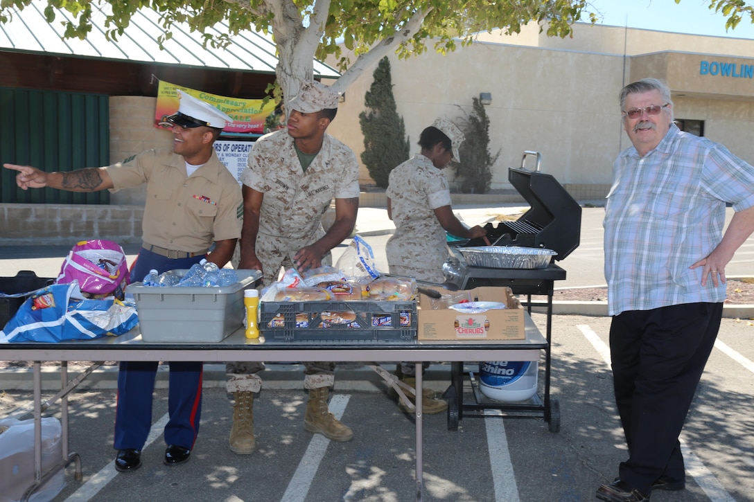 Sgt. Xzavier Wolef, career planner, Pfc. Jacob Brown, adjutants clerk, and Cpl. Daija Watt, postal clerk, barbeque lunch for base employees as a fund raiser for the Marine Corps Ball Committee, aboard Marine Corps Logistics Base Barstow, Calif., Sept. 2.