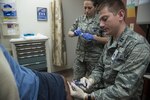 Capt. John Lax (right), 359th Medical Operations Squadron physician, injects medication into a patient’s knee May 2 at the Joint Base San Antonio-Randolph Medical Clinic.

