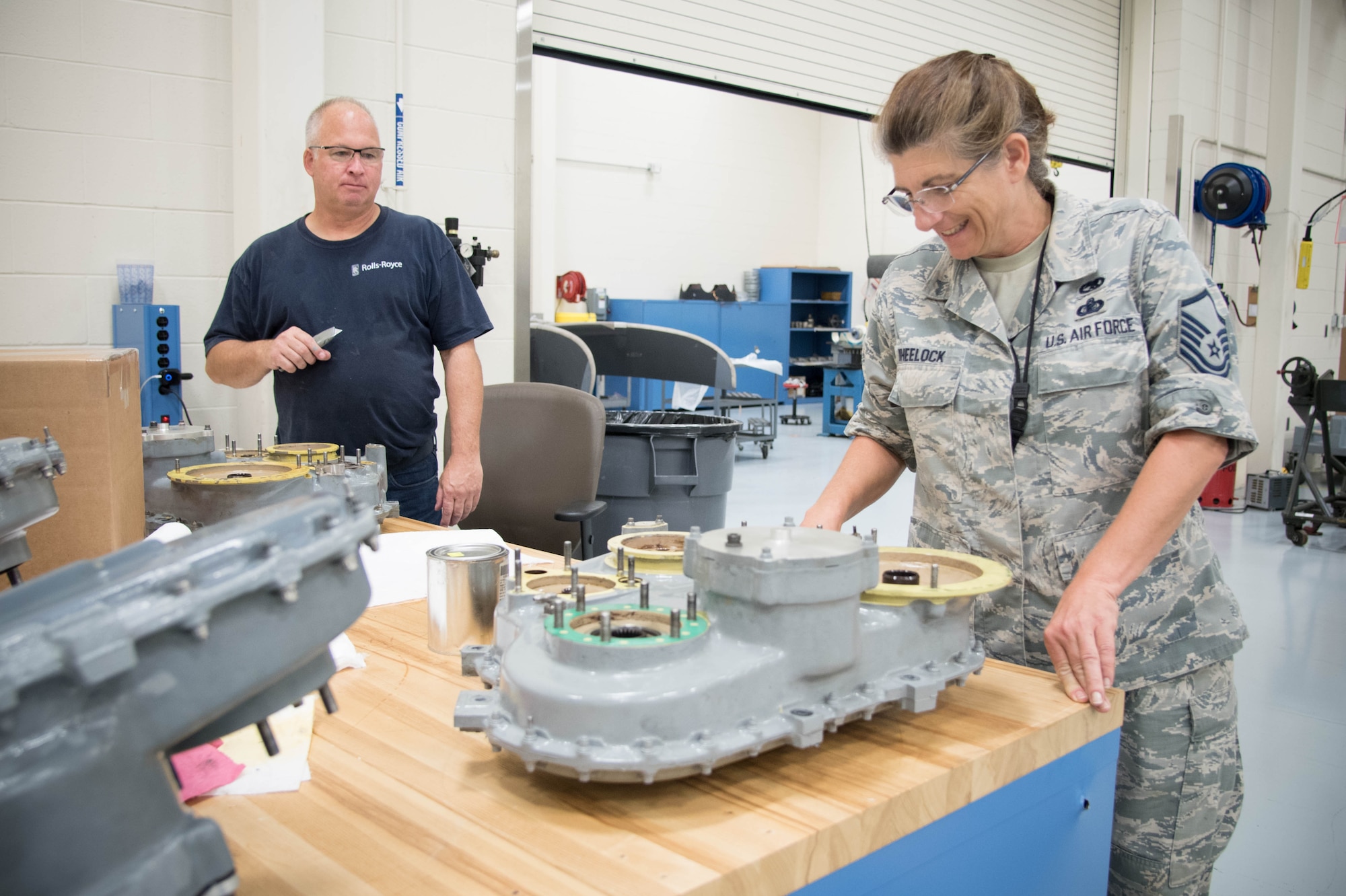 Master Sgt. Kathy Wheelock, 403rd Maintenance Squadron engine manager, and Frank Kraus, Rolls Royce airframe and power plant mechanic, look at a gear mounted accessory drive before installing a new propeller brake. Rolls Royce employees are traveling from base to base working with Airmen for a fleet-wide upgrade of engines in every C-130J aircraft.(U.S. Air Force photo/Senior Airman Heather Heiney)