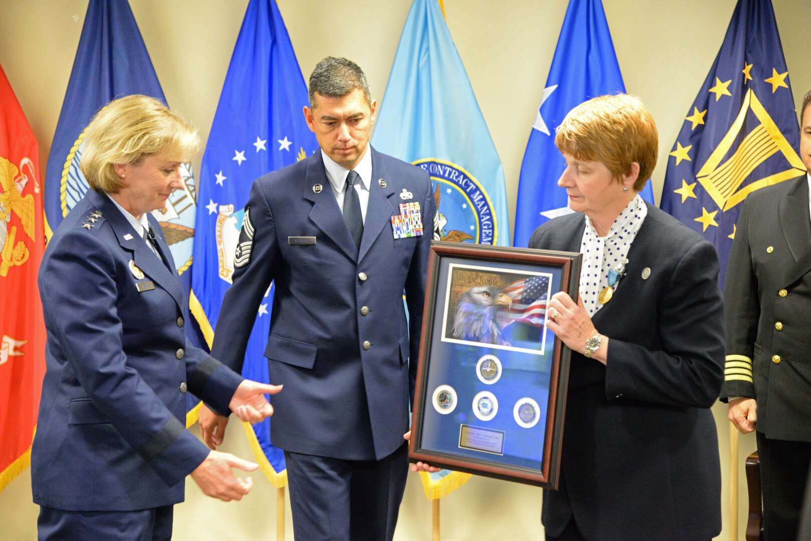 Air Force Lt. Gen. Wendy Masiello, Defense Contract Management Agency director, accepts a plaque commemorating the retirement of the agency's Operations Directorate from Chief Operations Officer Marie Greening. A Sept. 22 ceremony at Fort Lee, Virginia, signaled the transition of operational authority to the agency's regional commands. 
