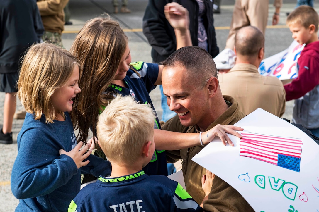 Navy Senior Chief Petty Officer Chad Sweetser hugs his children after returning home to Naval Air Station Whidbey Island, Wash., Sept. 23, 2016. Sweetser is an aviation electronics technician assigned to Patrol Squadron 40, which conducted reconnaissance operations in the 5th and 7th Fleet areas of responsibility. Navy photo by Petty Officer 3rd Class Caleb Cooper