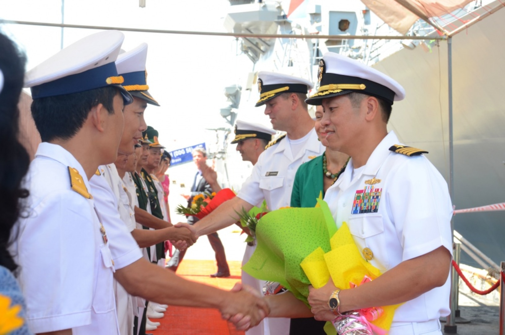 Capt. H. B. Le, commodore, Destroyer Squadron 7, shakes hands with members of the Vietnam People's navy during a welcome ceremony in Da Nang in support of Naval Engagement Activity (NEA) Vietnam 2016. In its seventh year, NEA Vietnam is designed to foster mutual understanding, build confidence in the maritime domain and strengthen relationships between the U.S. Navy, Vietnam People's navy and the local community. 