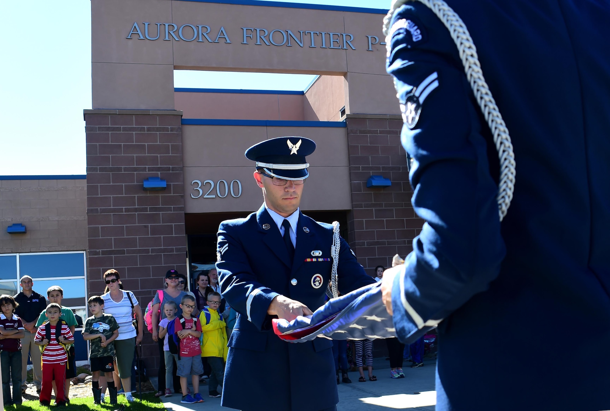 Airman 1st Class Paul Lombardi, U.S. Air Force Mile High Honor Guard member, folds the American flag during a demonstration Sep. 27, 2016, at Aurora Frontier P-8 in Aurora, Colo. Members of the honor guard volunteered to put on a demonstration for elementary students to educate them on properly lowering and folding the flag. (U.S. Air Force photo by Airman Holden S. Faul/ Released)