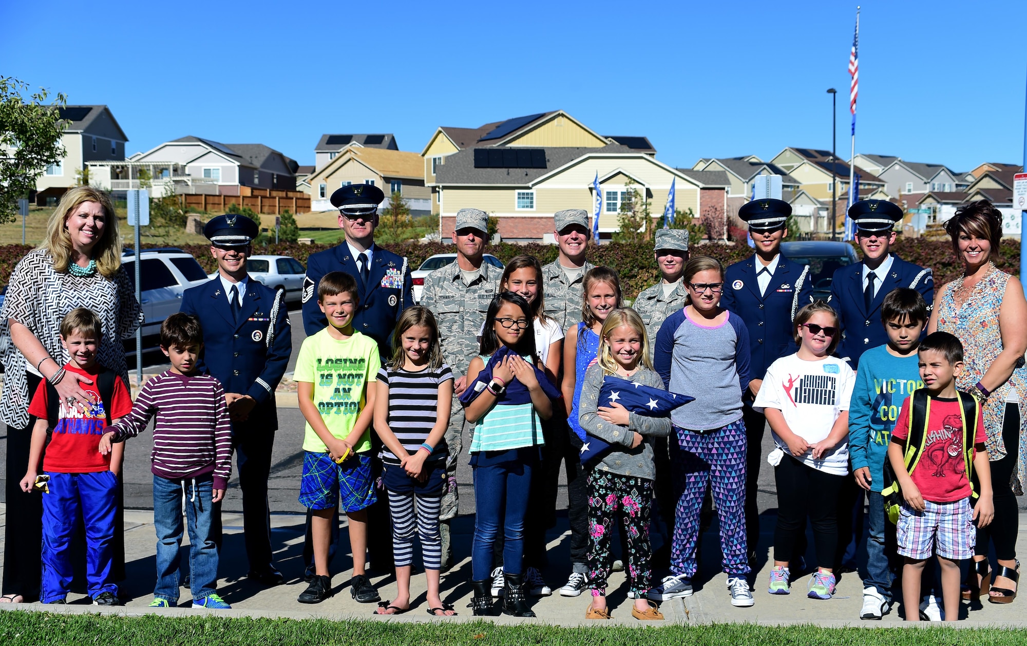 U.S. Air Force Mile High Honor Guard members stand with students and faculty after demonstrating and teaching them how to properly lower and fold the American flag Sep. 27, 2016, at Aurora Frontier P-8 in Aurora, Colo. Members of the honor guard volunteered to put on a demonstration for elementary students to educate them on proper flag etiquette. (U.S. Air Force photo by Airman Holden S. Faul/ Released)