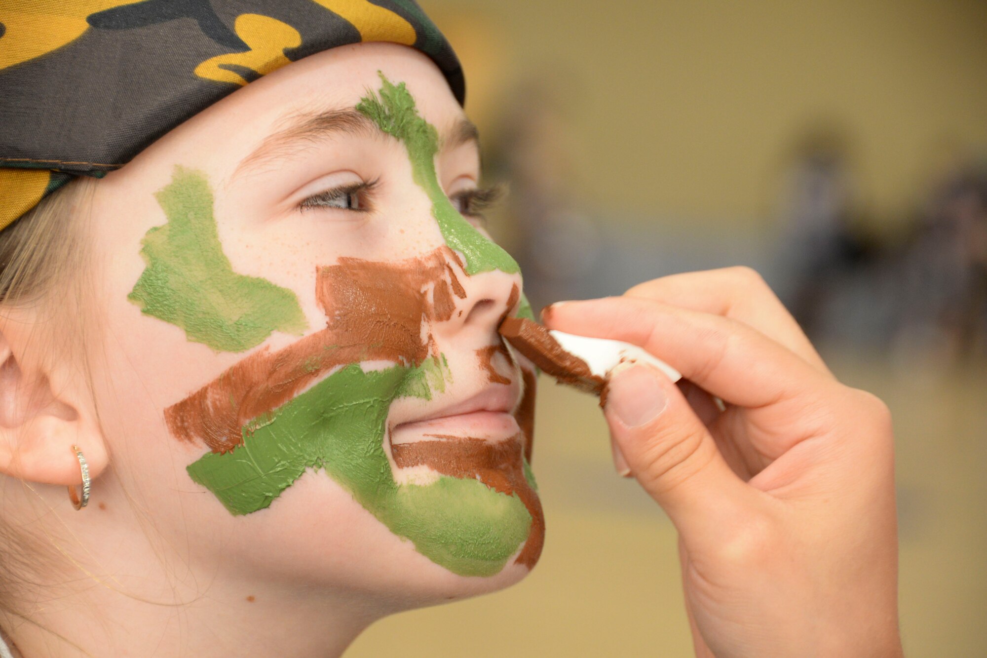 An Operation Hero recruit gets her face painted during Operation Hero 2016 at Barksdale Air Force Base, La., Sept. 24. The annual event allows children to have a better understanding of what Airmen go through before deploying. Along with running through a personnel deployment function line the recruits got their faces painted, tasted meals-ready-to-eat and learned about real world events that military members face every day. (U.S. Air Force photo/Senior Airman Amanda Morris)