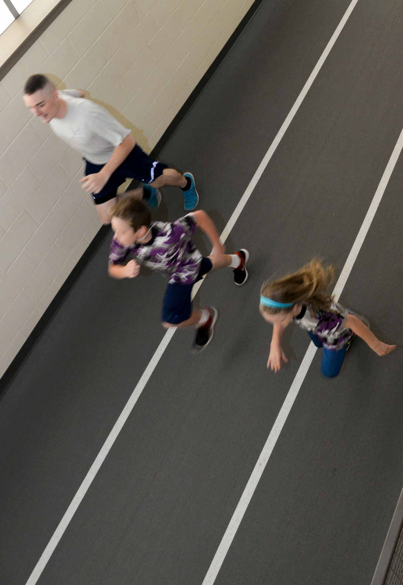 Senior Airman Anthony Wooldridge, Operation Hero volunteer, runs with recruits during their mock physical fitness test during Operation Hero 2016 at Barksdale Air Force Base, La., Sept. 24. Operation Hero is an annual event for children to participate in a mock deployment line. The event allows children to have a better understanding of what Airmen go through before deploying.  (U.S. Air Force photo/Senior Airman Amanda Morris)