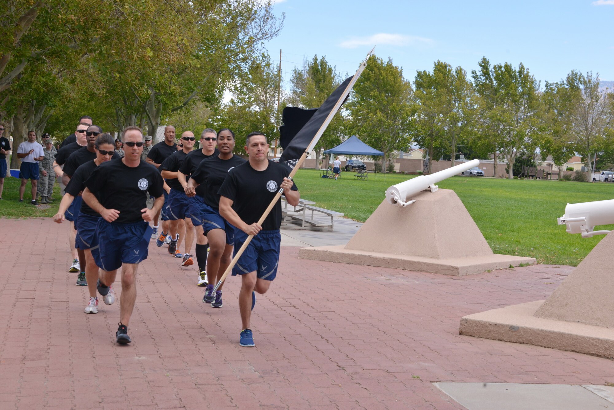 Master Sgt. John Lopez of the 351st Battlefield Airman Training Squadron carries the prisoner of war/missing in
action flag as he runs with other first sergeants at the beginning of the 24-hour POW/MIA vigil run Sept. 15 at Hardin Field. The run ended Sept. 16 at the New Mexico Veterans Memorial, where Team Kirtland members held a
ceremony. (Photo by Dennis Carlson)