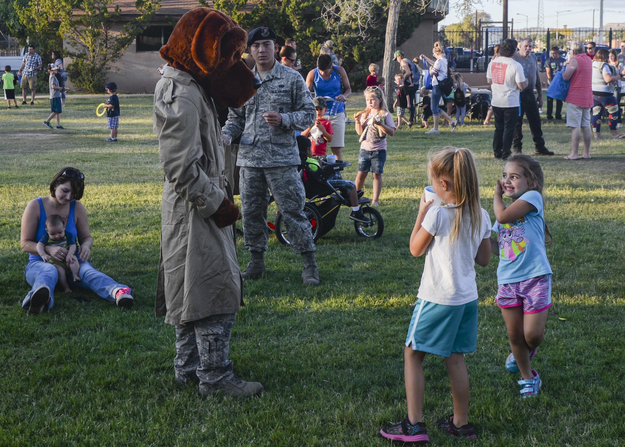 A security forces member wearing a McGruff the Crime Dog costume greets two children during the annual Zoo After Hours event at Alameda Park Zoo in Alamogordo, N.M. on Sept. 24, 2016. McGruff the Crime Dog is a cartoon bloodhound that helps to raise crime awareness among children. (U.S. Air Force photo by Airman 1st Class Alexis P. Docherty) 