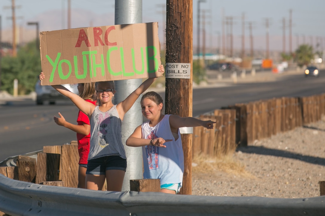 The American Red Cross Youth Group advertises a yard and bake sale by Del Valle Road aboard Marine Corps Air Ground Combat Center Twentynine Palms, Calif., Sept. 17, 2016. The event was used as a fund raiser for the youth group and charities. (Official Marine Corps photo by Cpl. Thomas Mudd/Released)