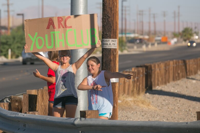 The American Red Cross Youth Group advertises a yard and bake sale by Del Valle Road aboard Marine Corps Air Ground Combat Center Twentynine Palms, Calif., Sept. 17, 2016. The event was used as a fund raiser for the youth group and charities. (Official Marine Corps photo by Cpl. Thomas Mudd/Released)