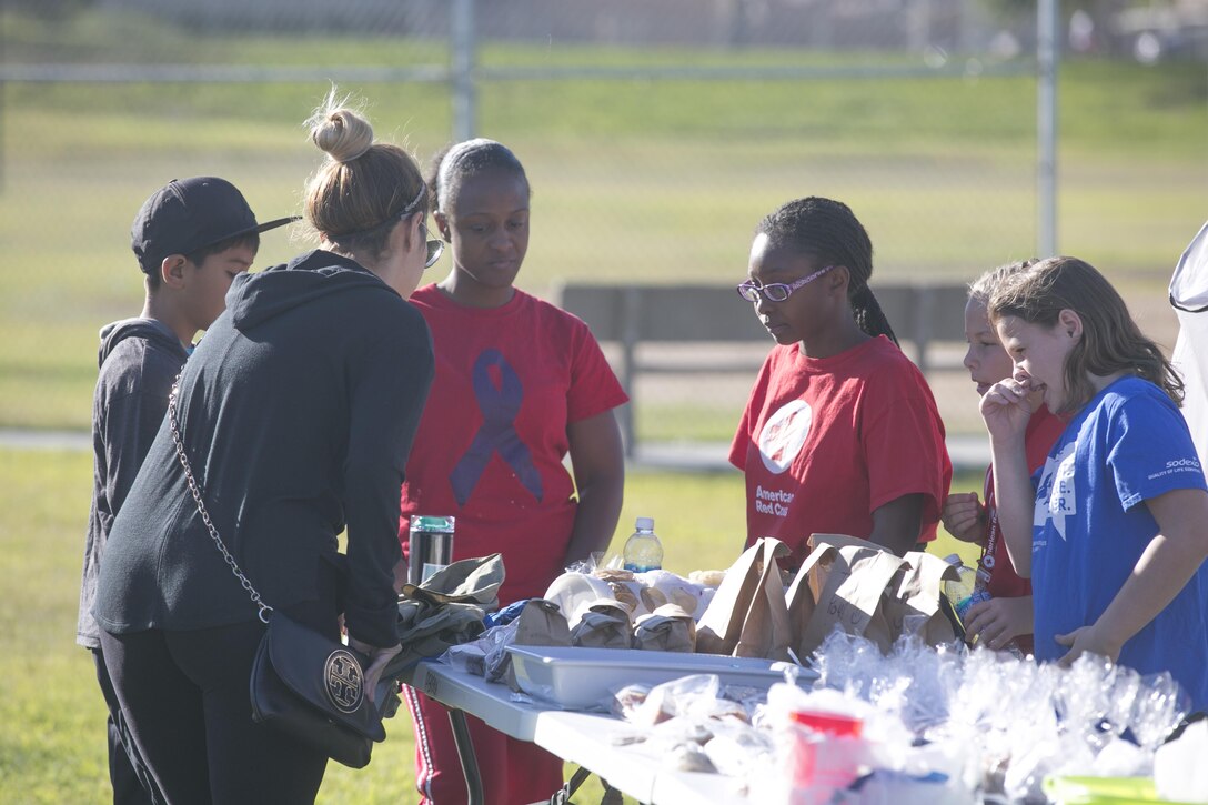 The American Red Cross Youth Group sell baked goods to the Combat Center patrons during a yard and bake sale at the Lincoln Military Housing Athletic Field aboard Marine Corps Air Ground Combat Center Twentynine Palms, Calif., Sept. 17, 2016. The event was used as a fund raiser for the youth group and charities. (Official Marine Corps photo by Cpl. Thomas Mudd/Released)