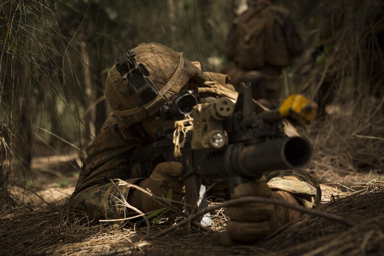 KAHUKU TRAINING FACILITY – A Marine provides security during a patrol as part of a training exercise aboard the Kahuku Training Facility, Sept. 20, 2016. The exercise is part of a 7-week-long training event known as the Advance Infantry Course. The Advance Infantry Course, which is conducted by the Advance Infantry Battalion, Detachment Hawaii, is an advanced 0311 (Rifleman) Military Occupational Specialty course for squad leaders who are currently serving in the operating field. Originally only for 3rd Marine Division, the course here has opened up to various infantry units throughout the Marine Corps. Marines start with a week of proofing their prerequisites that are required for the course, confirming their basic skill sets, and then spend two weeks in a garrison environment doing course work and physical training routines geared toward the squad leader. Towards the second half of the course, Marines conduct one live fire week, followed by three consecutive weeks in the field, progressing from an urban exercise to a patrolling exercise, with offensive and defensive tactics. Marines trained in multiple areas on the island, from high in the mountains of the Kahuku Training Facility to the Military Operation in Urban Terrain facilities on Marine Corps Training Area Bellows. (U.S. Marine Corps Photo by Lance Cpl. Jesus Sepulveda Torres)