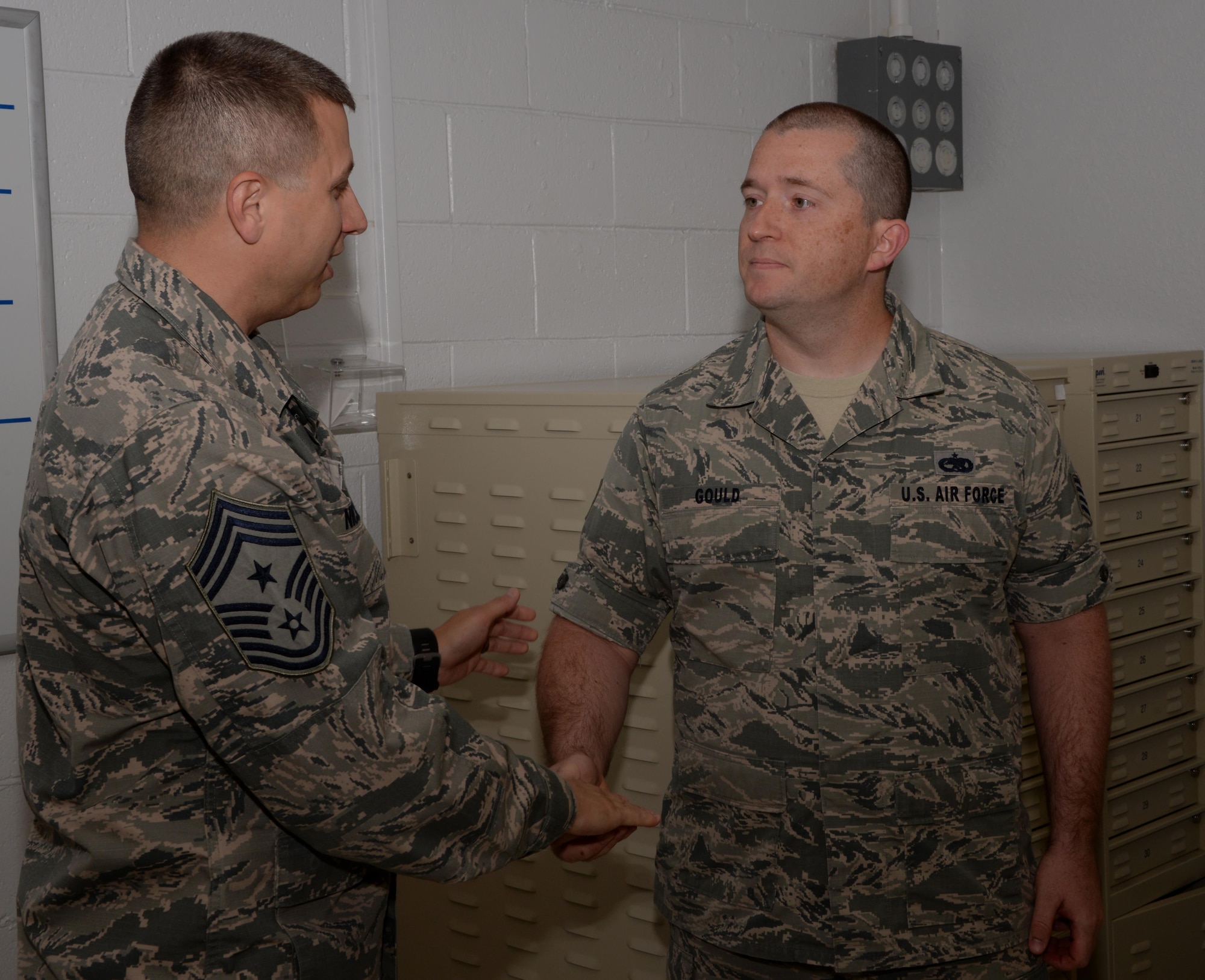 Chief Master Sgt. Steve Nichols (Left), 60th Air Mobility Wing command chief, presents his coin to Staff Sgt. Timothy Gould (Right), 60th Maintenance Squadron precision measurement equipment laboratory technician from Buffalo, New York, at Travis Air Force Base, Calif., Sept. 27, 2016. Gould was recognized for his efforts as a master resiliency training instructor. He has helped provide resiliency training to more than 800 Airmen in 2016. (U.S. Air Force photo/Tech. Sgt. James Hodgman)